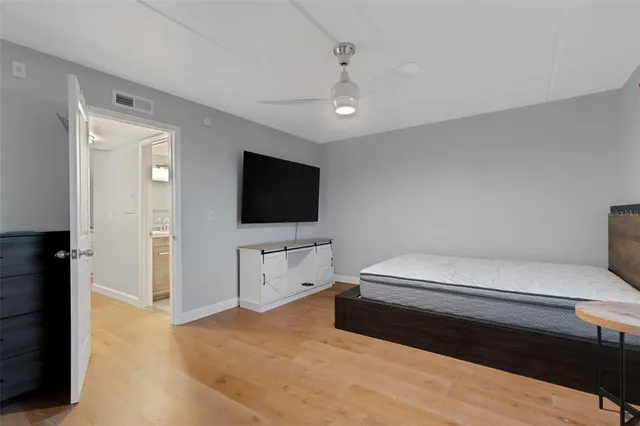 a spacious bedroom with a bed and a flat screen tv