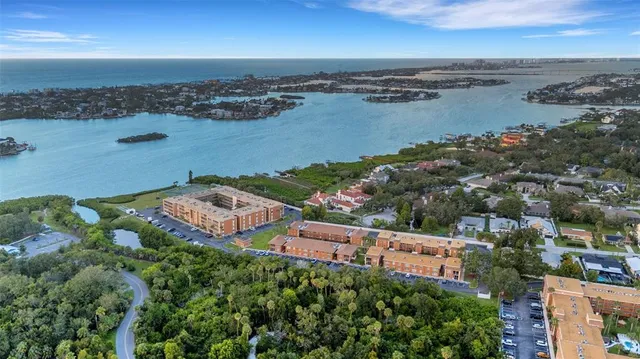 an aerial view of ocean and residential houses with outdoor space