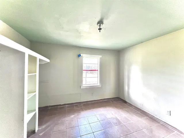 an empty room with windows and closet