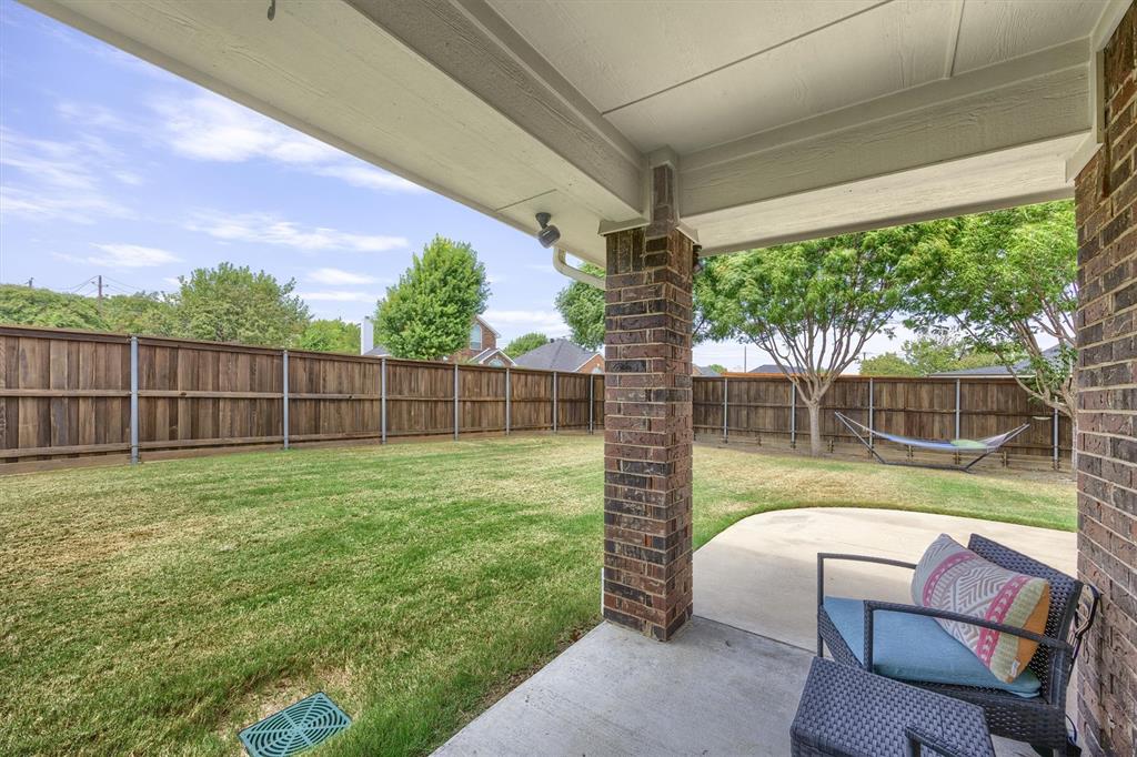 10714 Huntington Road Frisco, TX 75035 - Photo 21 of 24 Expansive backyard featuring a manicured lawn, full privacy fencing, and a covered concrete patio