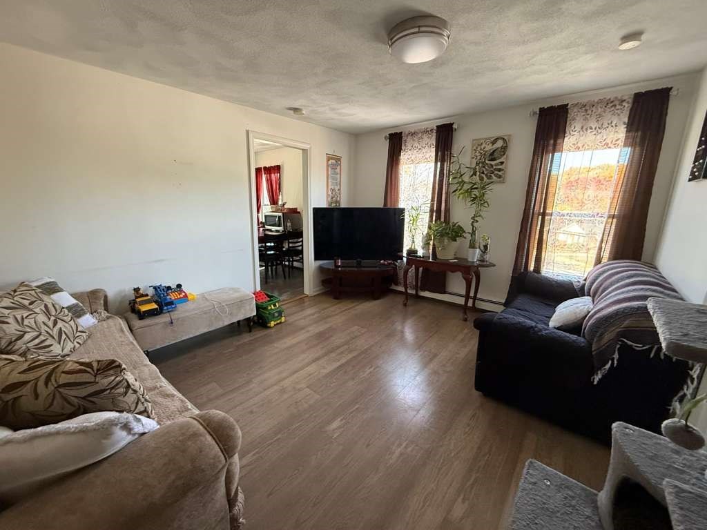 642-648 Eastern Avenue, Unit 3 Lynn, MA 01902 - Photo 1 of 7 a living room with furniture and a flat screen tv
