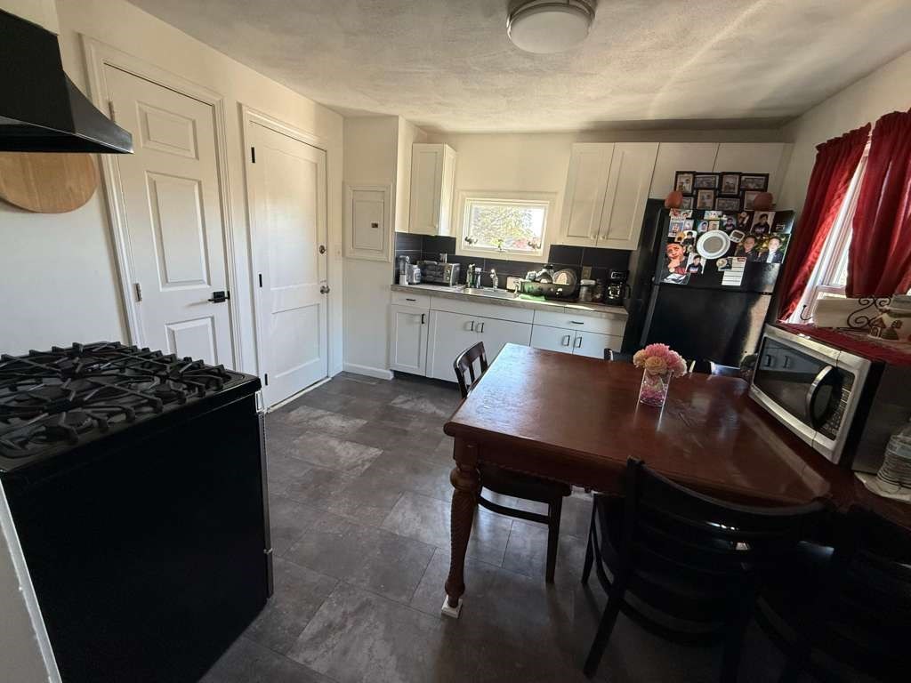 642-648 Eastern Avenue, Unit 3 Lynn, MA 01902 - Photo 2 of 7 a kitchen with stainless steel appliances granite countertop a stove and a refrigerator