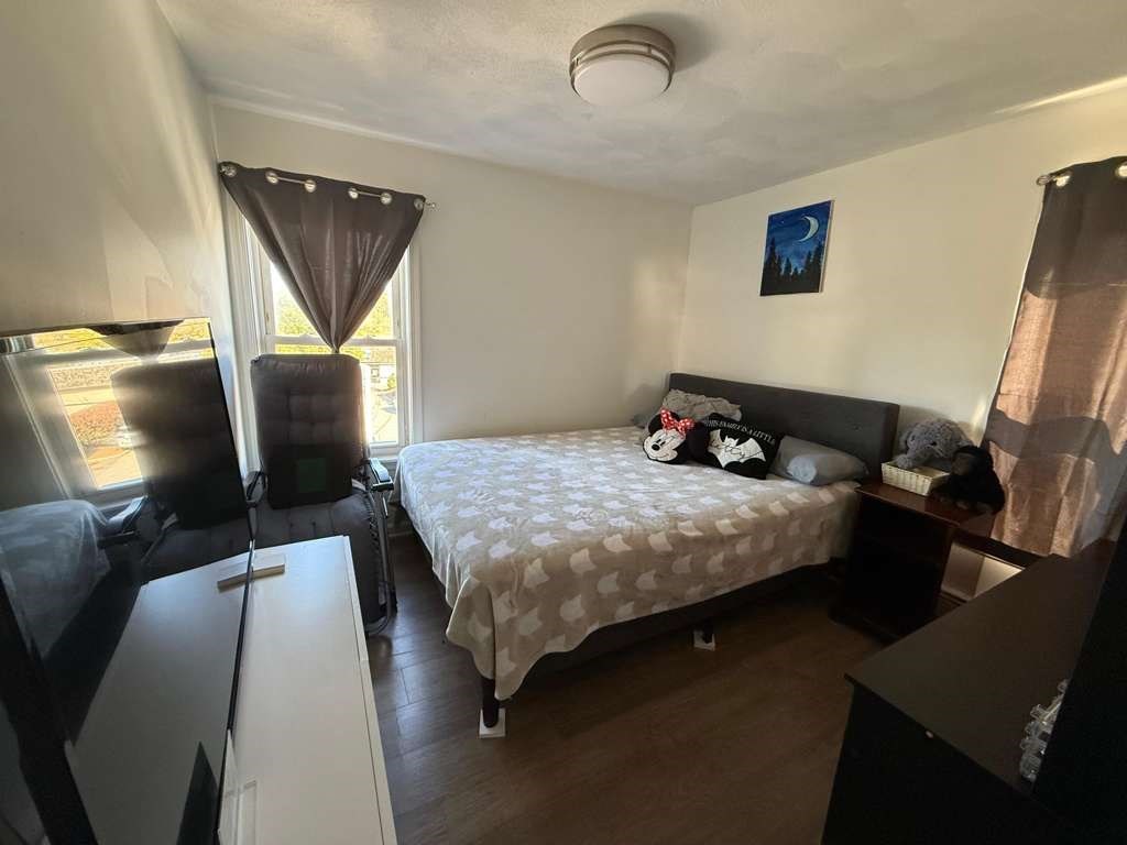 642-648 Eastern Avenue, Unit 3 Lynn, MA 01902 - Photo 4 of 7 a bedroom with a bed and flat screen tv