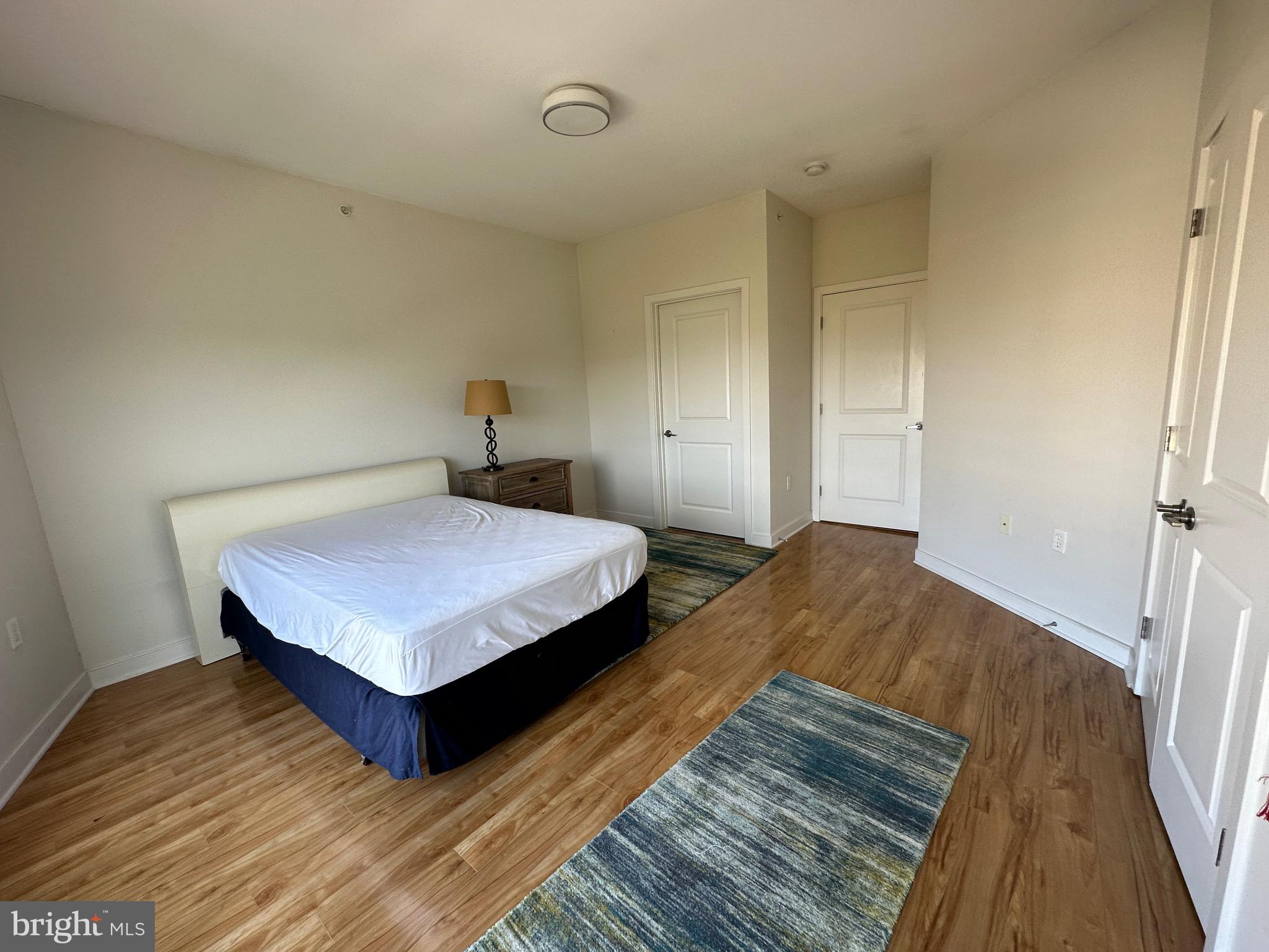 8005 13th Street, Unit 408 Silver Spring, MD 20910 - Photo 11 of 24 a bedroom with a bed and wooden floor