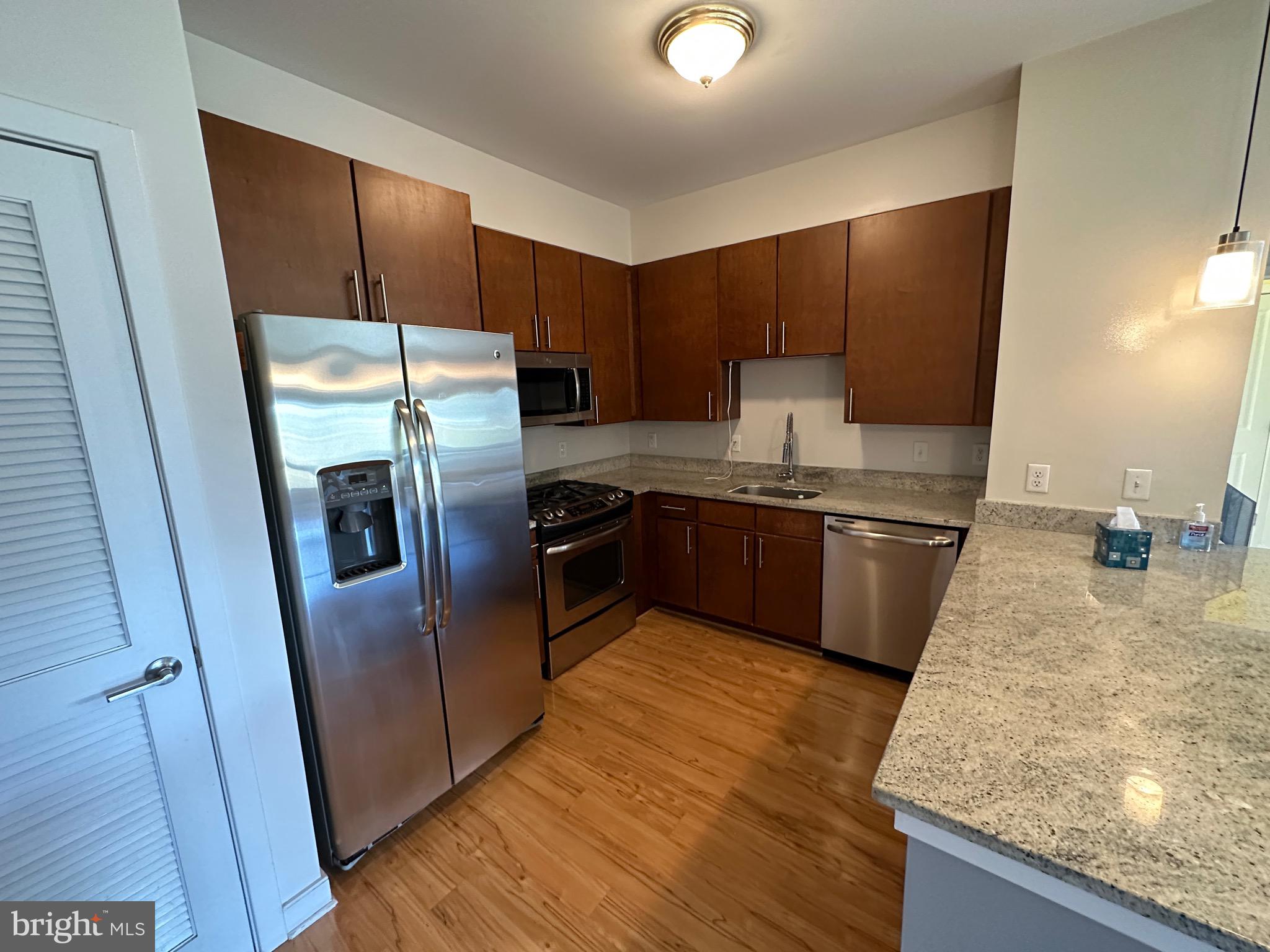 8005 13th Street, Unit 408 Silver Spring, MD 20910 - Photo 8 of 24 a kitchen with stainless steel appliances granite countertop a refrigerator a stove and a sink