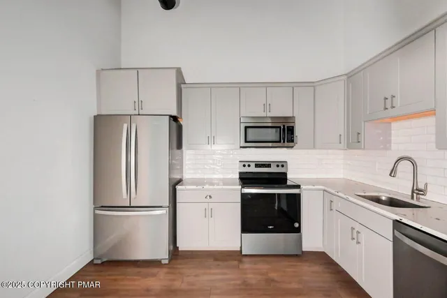 a kitchen with a refrigerator sink and white stove