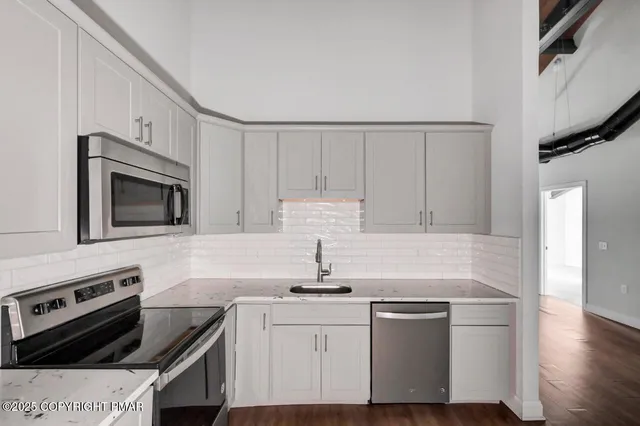 a kitchen with stainless steel appliances a sink stove and cabinets