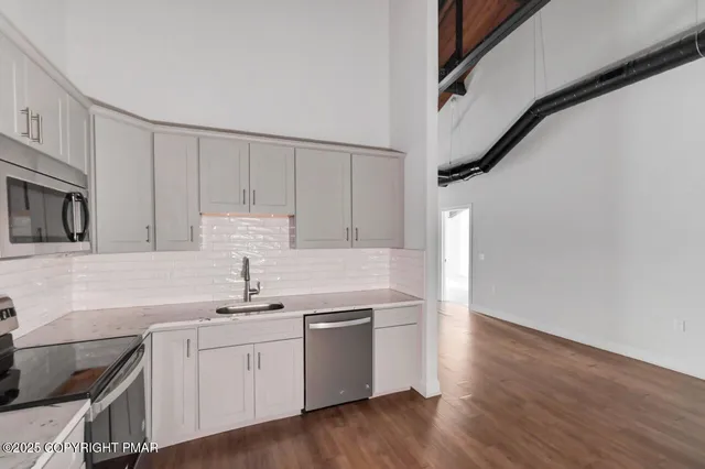 a kitchen with a sink cabinets and stainless steel appliances