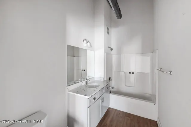 a bathroom with a granite countertop sink a toilet and shower