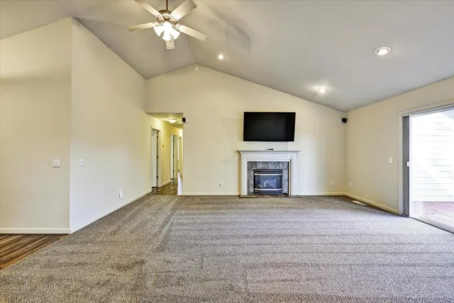 a view of empty room with a fireplace and flat screen tv