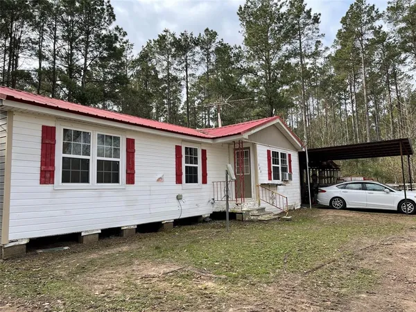 a view of a house with a yard and sitting area