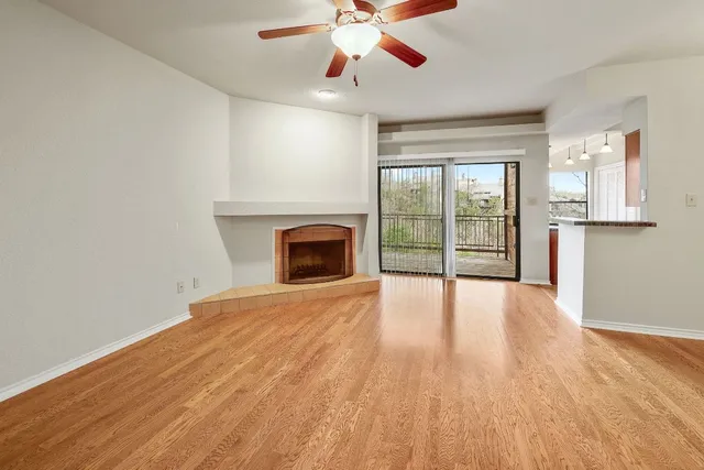 a view of empty room with wooden floor and fireplace