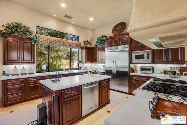 a kitchen with stainless steel appliances granite countertop a stove a sink dishwasher and refrigerator with wooden floor