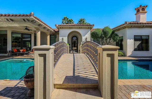 a view of a house with large windows and a small yard