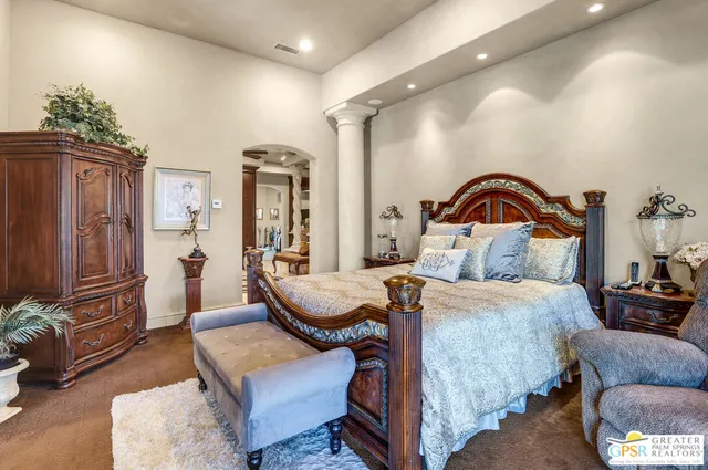 a bedroom with a bed a couch and a flat tv screen