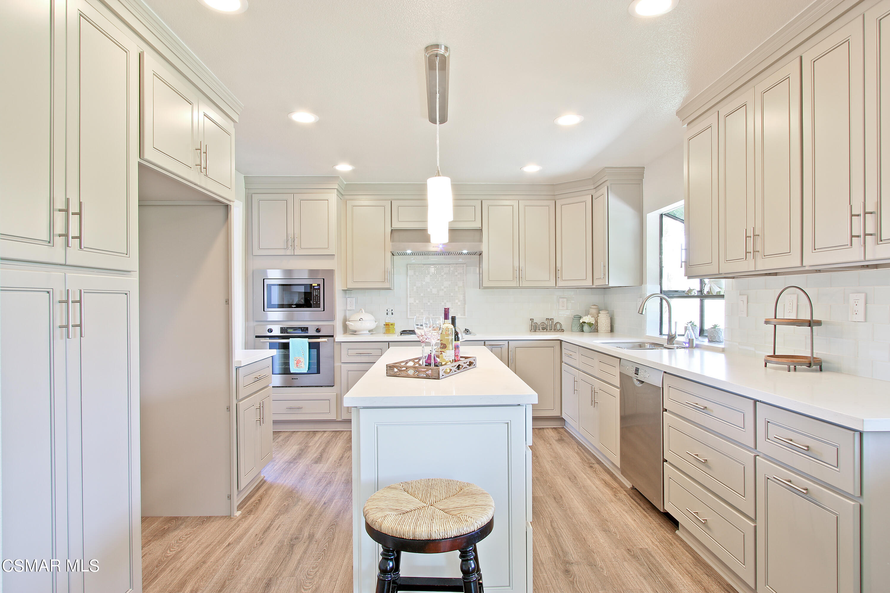 2624 Lemon Drive Simi Valley, CA 93063 - Photo 5 of 22 a kitchen with a sink stove and white cabinets with wooden floor