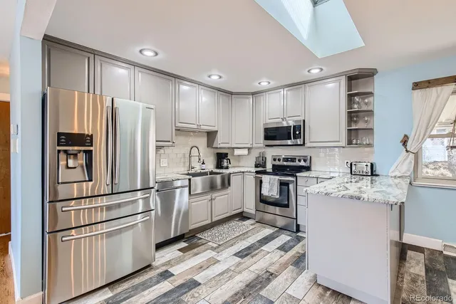 a kitchen with stainless steel appliances granite countertop a refrigerator stove and microwave