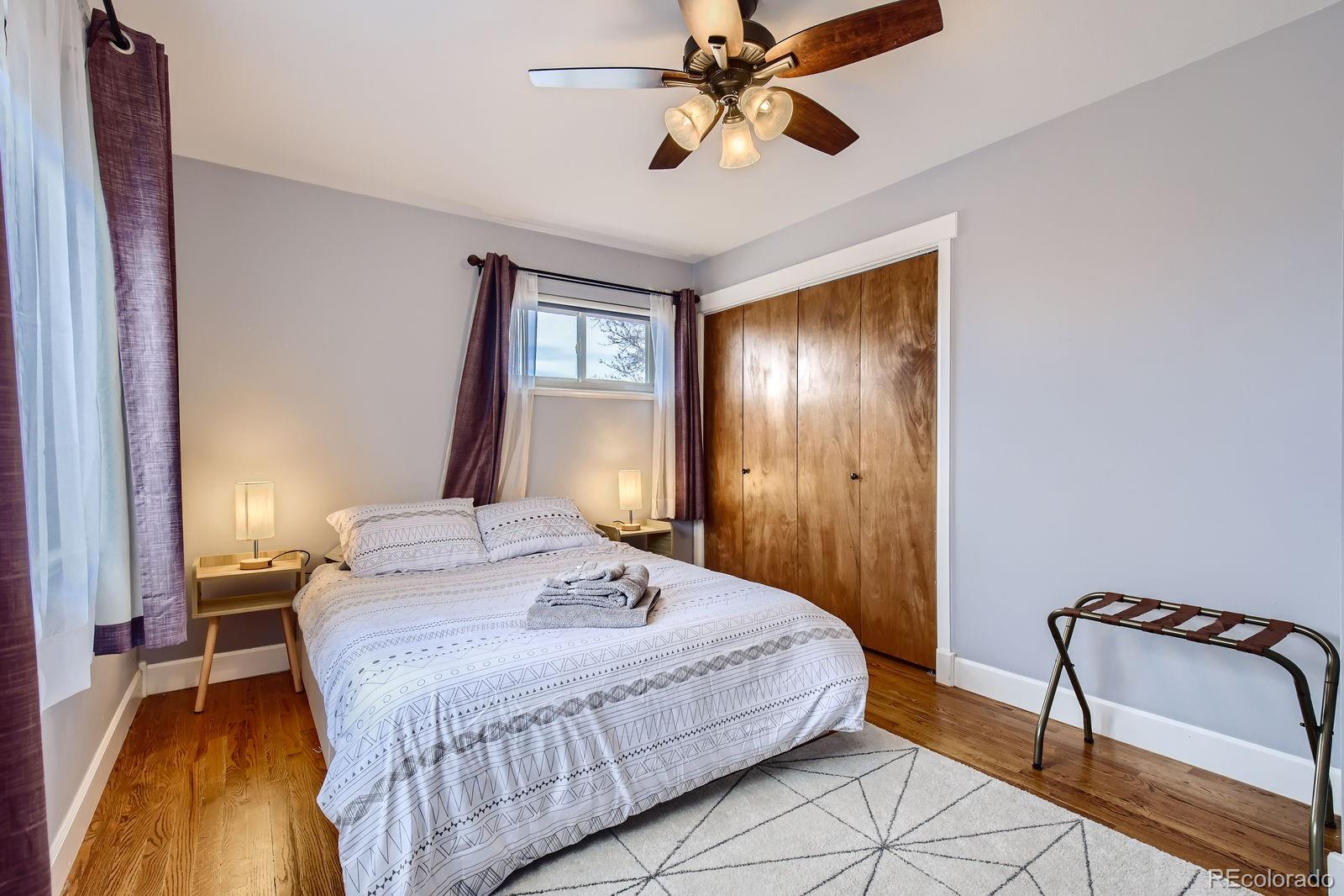 6614 Gray Street Arvada, CO 80003 - Photo 5 of 19 a bedroom with a bed and a chandelier