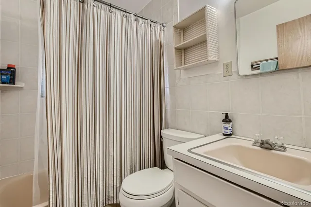 a bathroom with a sink a toilet and shower curtain