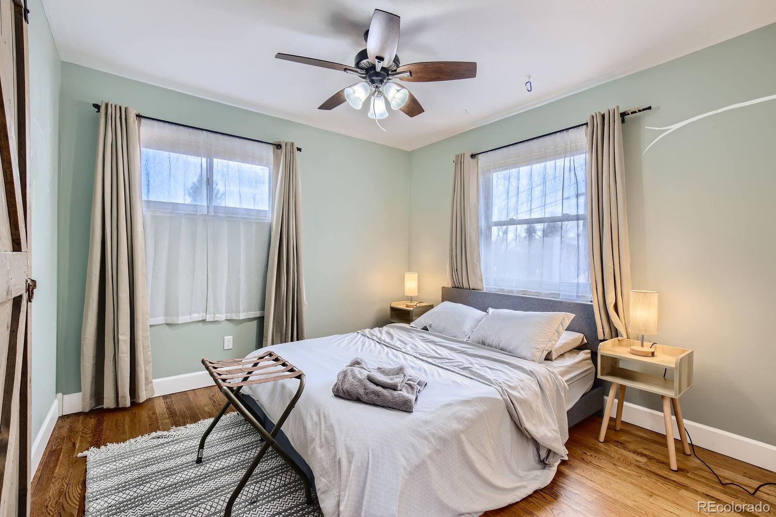6614 Gray Street Arvada, CO 80003 - Photo 7 of 19 a bedroom with a bed and a chandelier