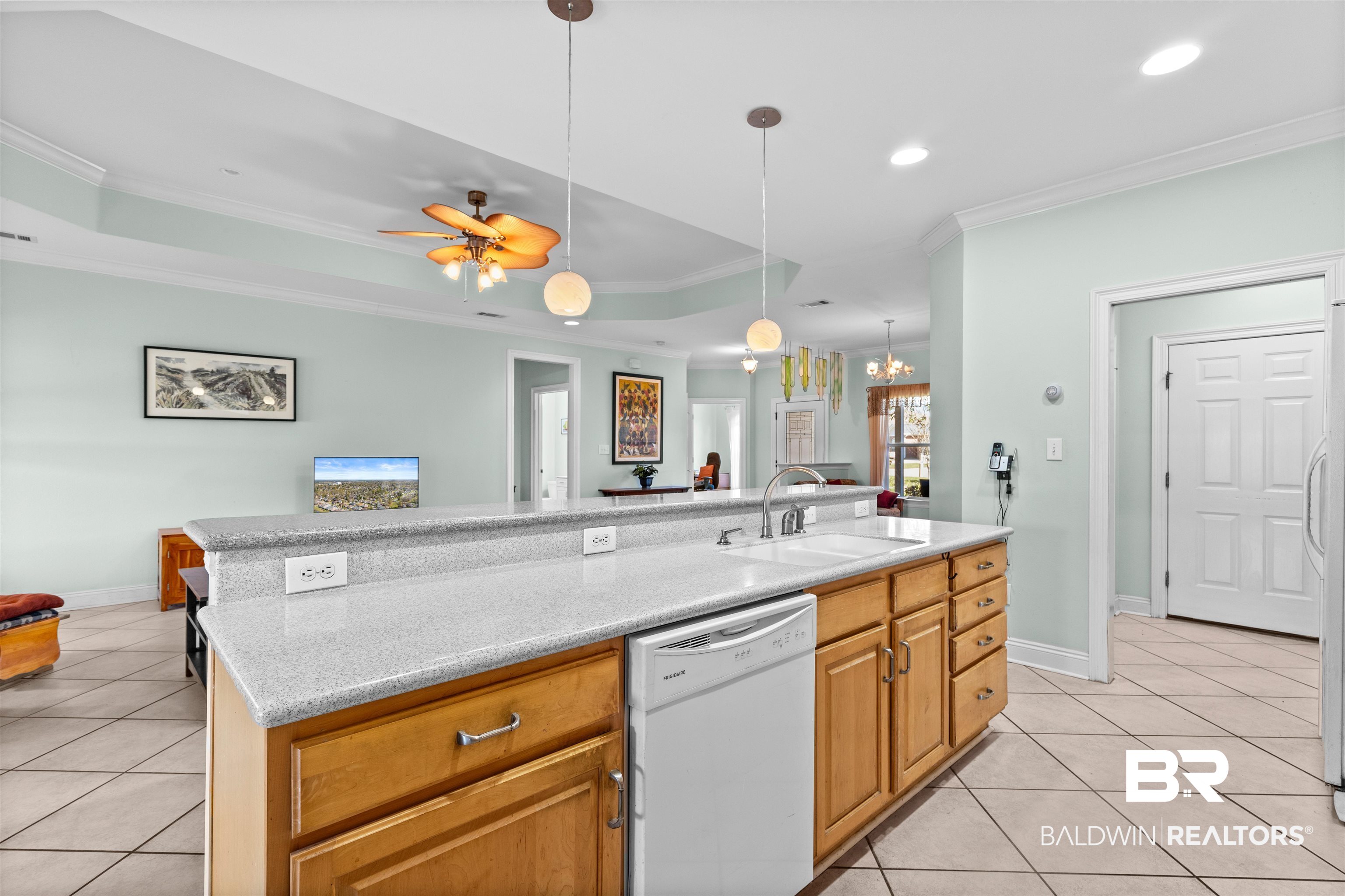237 Hemingway Loop Foley, AL 36535 - Photo 12 of 49 Kitchen with dishwasher, a tray ceiling, ornamental molding, light tile patterned flooring, and a sink