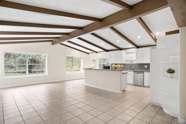 a kitchen with a stove a refrigerator and white cabinets