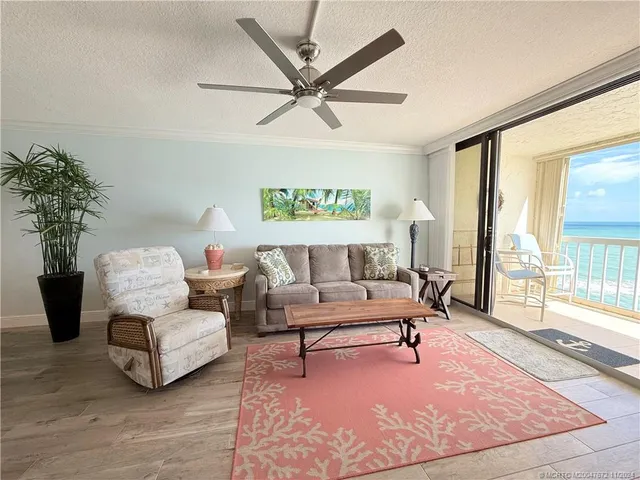 a living room with furniture and a large window with wooden floor