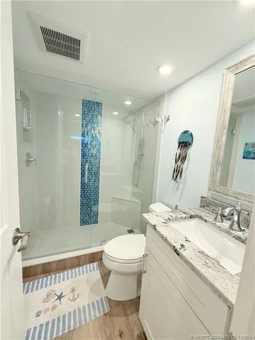 a bathroom with a sink a toilet and shower