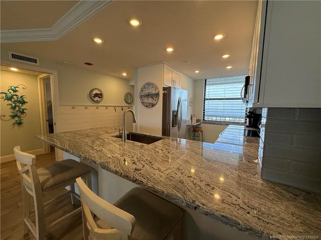 a view of a kitchen with kitchen island granite countertop a sink and stove