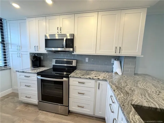 a kitchen with stainless steel appliances granite countertop a stove and a microwave