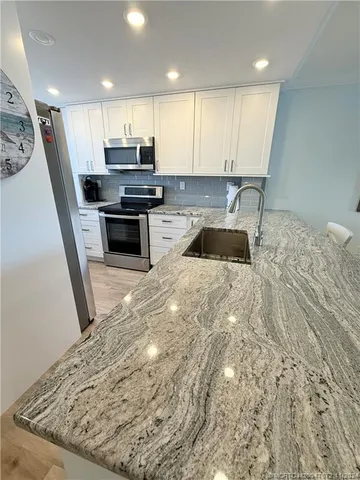 a kitchen with granite countertop a stove and a sink