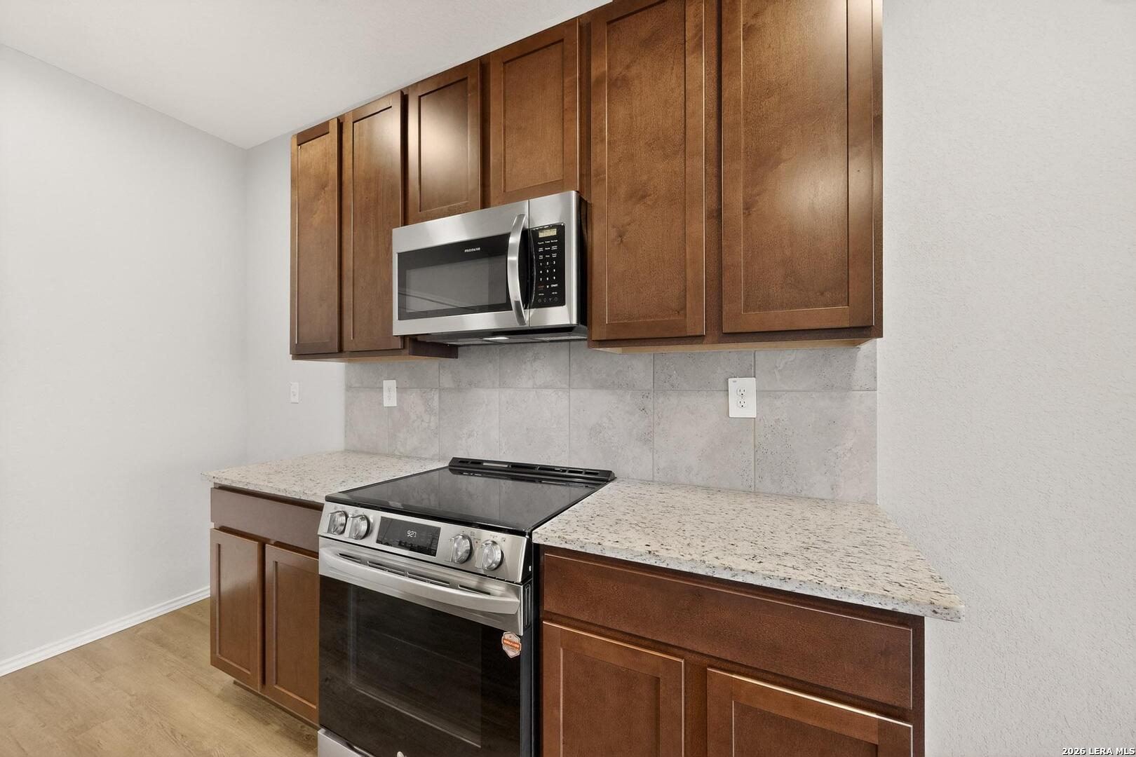 3038 Laguna Cliffs Converse, TX 78109 - Photo 12 of 32 a kitchen with granite countertop cabinets stainless steel appliances and wooden floor