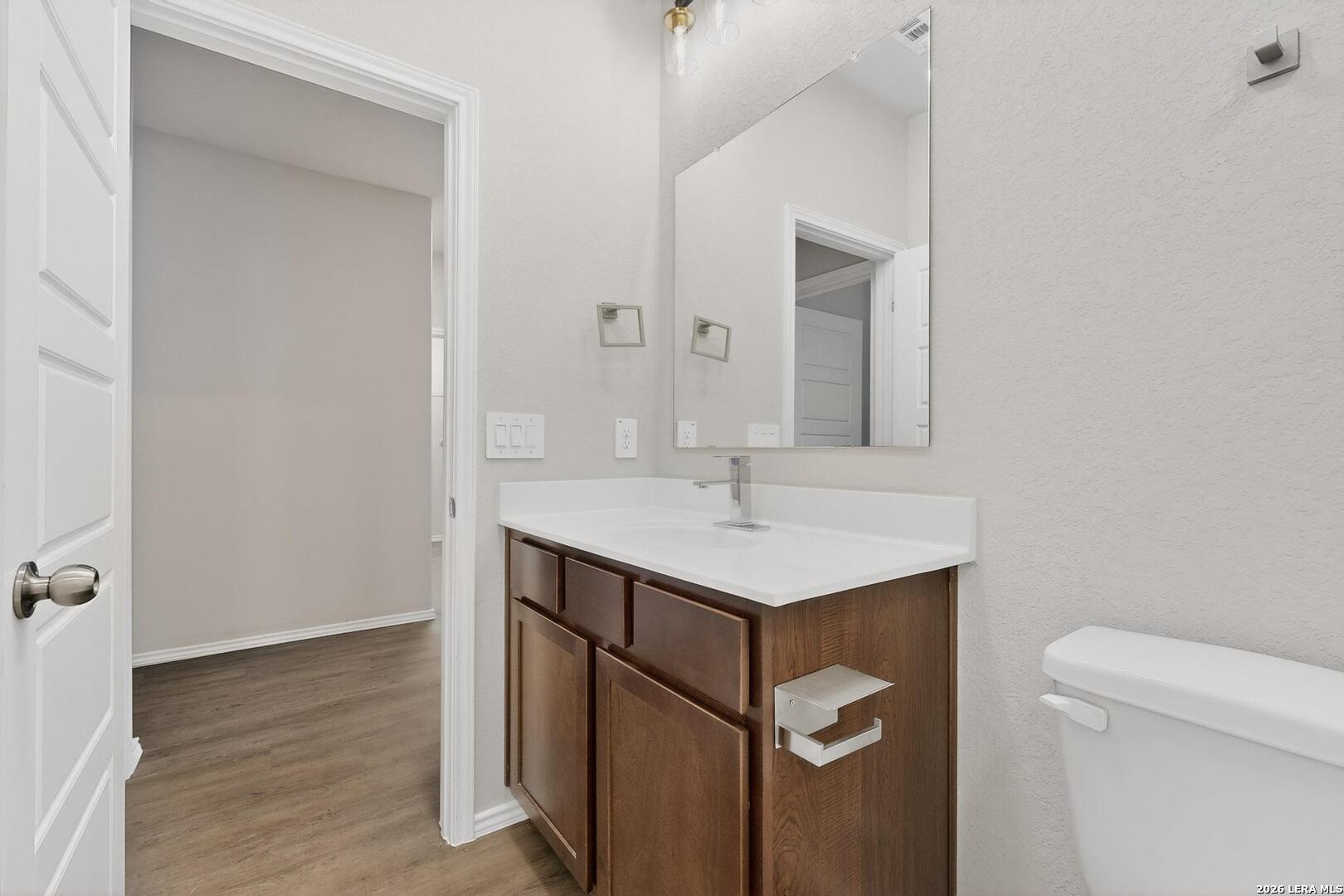 3038 Laguna Cliffs Converse, TX 78109 - Photo 14 of 32 a bathroom with a sink a toilet and a mirror