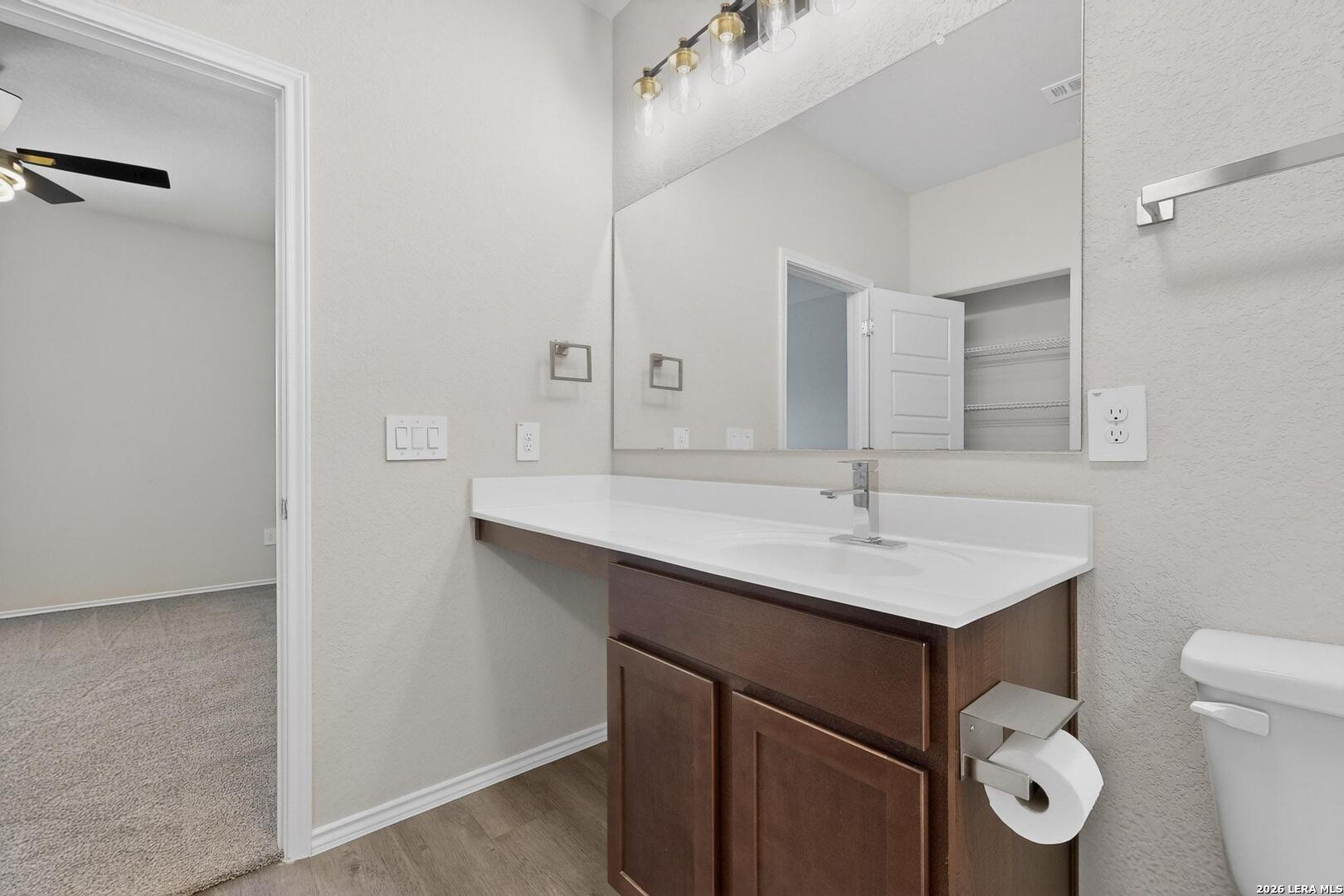 3038 Laguna Cliffs Converse, TX 78109 - Photo 20 of 32 a bathroom with a sink a toilet and a mirror