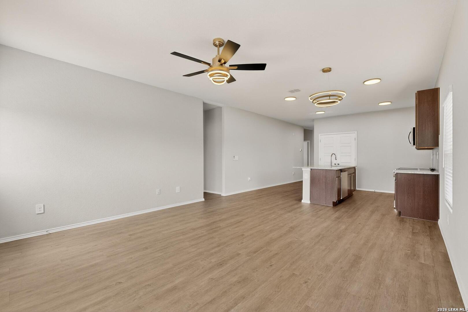 3038 Laguna Cliffs Converse, TX 78109 - Photo 6 of 32 a view of a livingroom with a ceiling fan and wooden floor