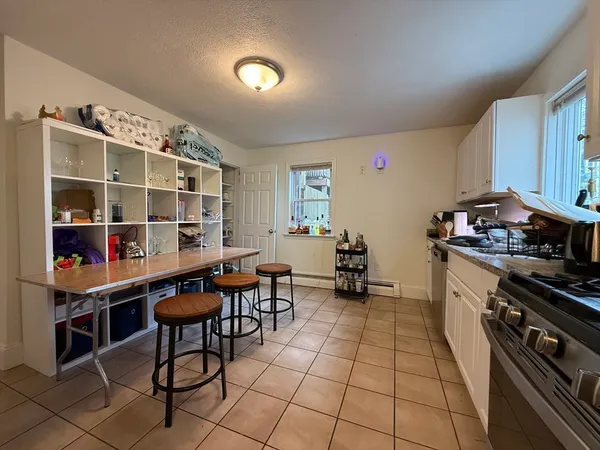 a kitchen with granite countertop a stove a sink and a wooden cabinets
