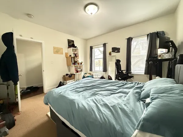 a bedroom with a bed and a flat tv screen on a dresser