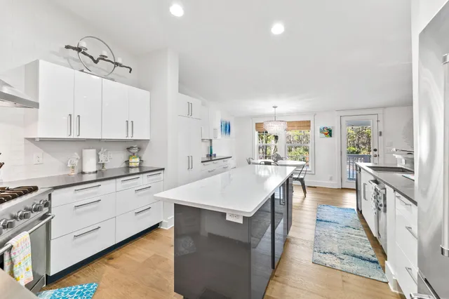 a large kitchen with stainless steel appliances granite countertop a lot of counter space and wooden floors