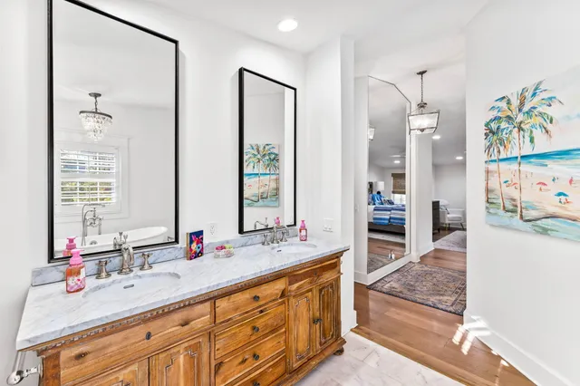 a bathroom with double vanity sinks a vanity a large mirror and a shower