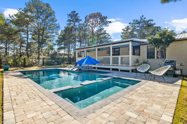 a view of a house with swimming pool and sitting area