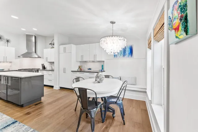 a kitchen with stainless steel appliances a dining table chairs and a refrigerator