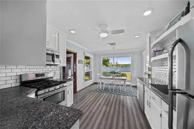 a kitchen with stainless steel appliances a stove a sink and a refrigerator