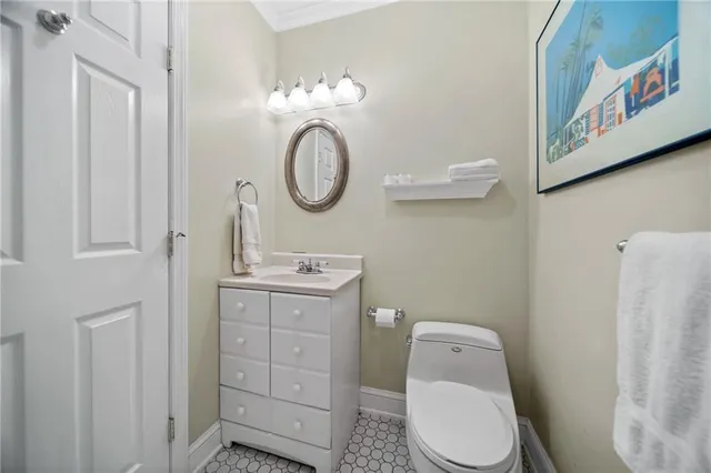 a bathroom with a toilet sink vanity and mirror