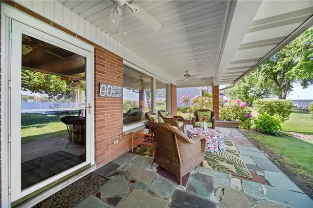 a view of a patio with table and chairs potted plants with floor to ceiling window