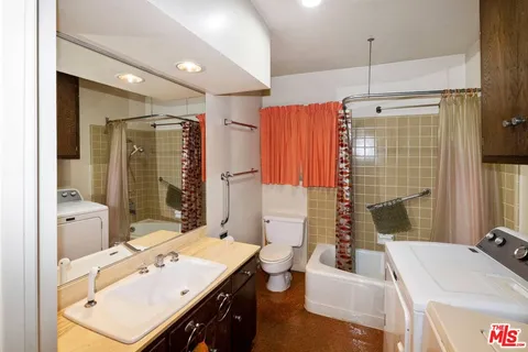 a bathroom with a sink tub double vanity and mirror