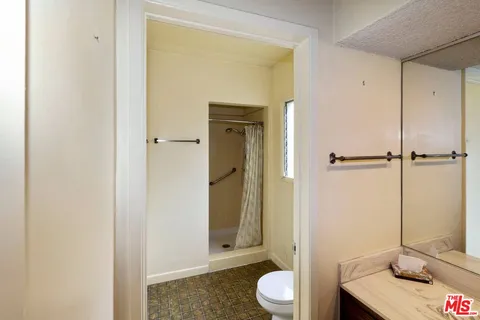 a bathroom with a granite countertop sink toilet and shower