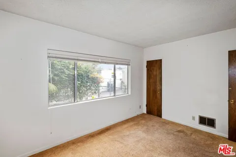 a view of a big room with windows and chandelier fan