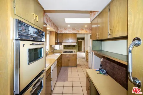 a kitchen with granite countertop a stove a sink and a microwave