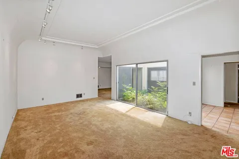 a view of an empty room with glass door