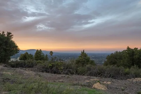 a view of sunset and green space